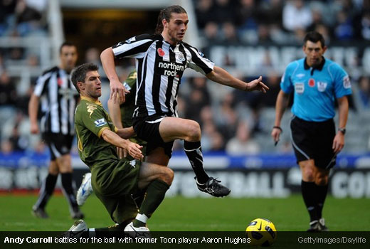 Andy Carroll battles for the ball with former Toon player Aaron Hughes
