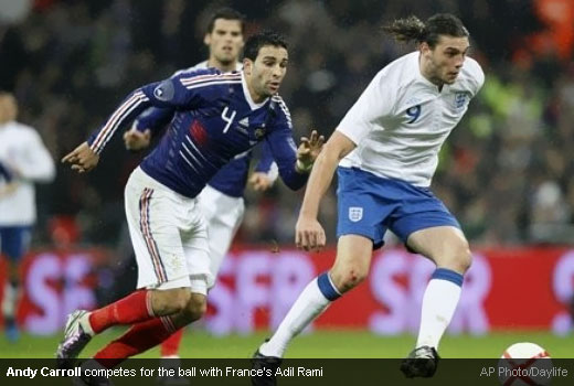 Andy Carroll competes for the ball with France's Adil Rami