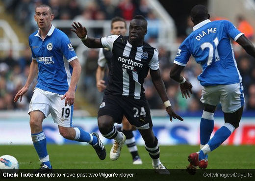 Cheik Tiote attempts to move past two Wigan’s player [MagpiesZone/GettyImages/DayLife]