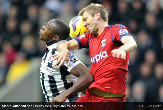 Shola Ameobi and Gareth McAuley jump for the ball